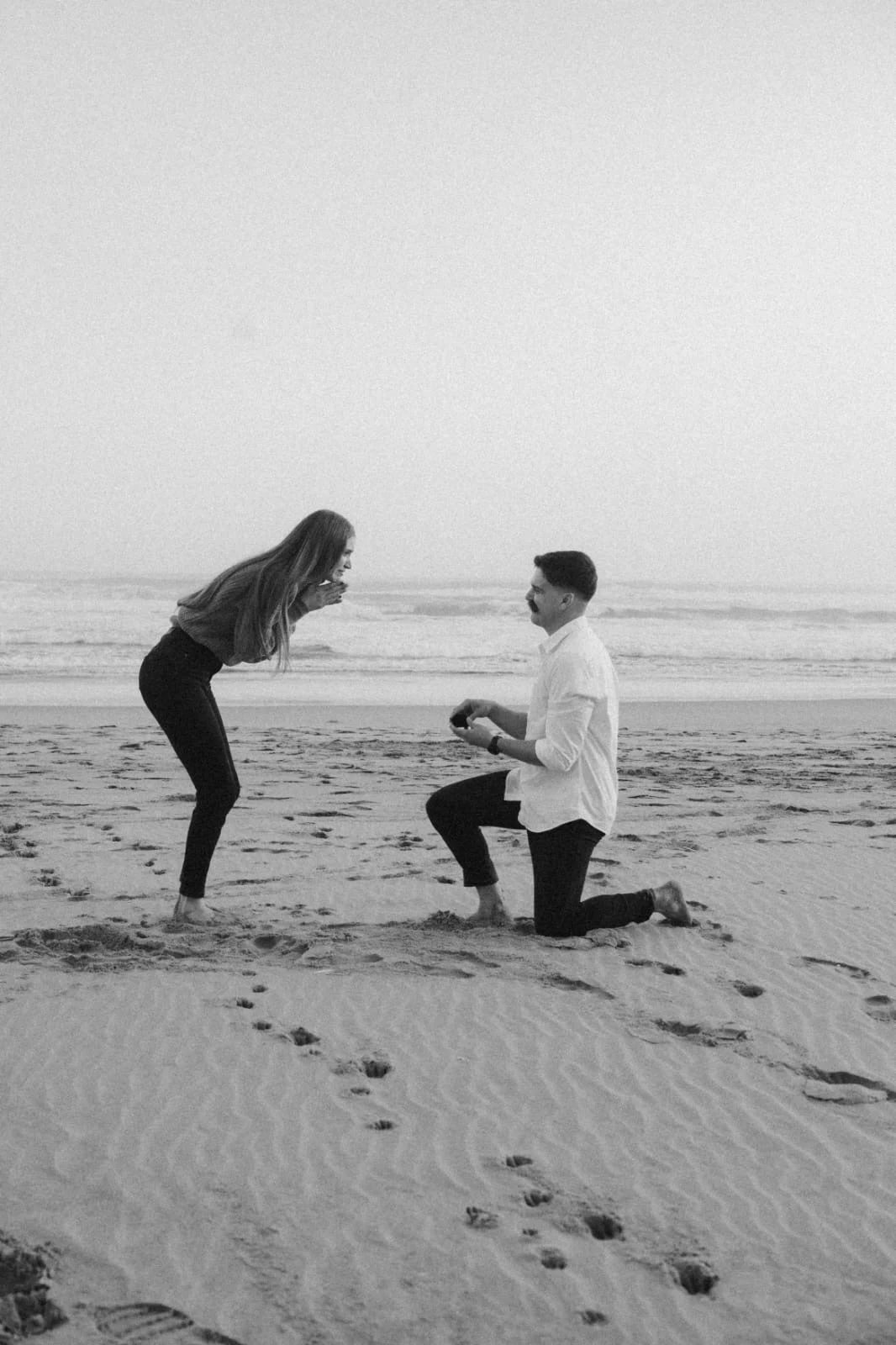 Ryan proposing to Katryn on the beach in Wilderness